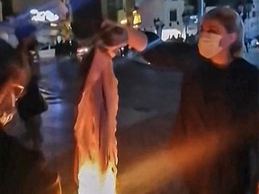 An Iranian protester burns her headscarf in Iran's southwestern city of Bushehr, on Sept. 25.
