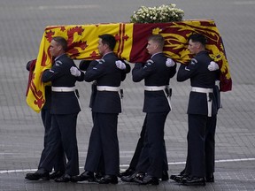 The coffin of Queen Elizabeth II is carried to a waiting hearse at RAF Northolt on Tuesday, from where it will be taken to Buckingham Palace, London to lie at rest overnight.