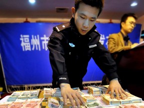 Police in the Chinese city of Fuzhou show off seized counterfeit money in this 2009 photo. Fuzhou security services have now set up at least three branch offices on Canadian soil.