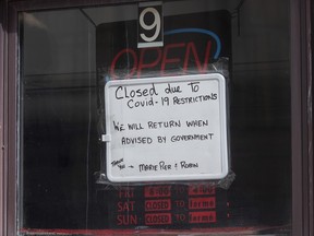 A sign in a barber shop window indicated the establishment was closed because of COVID-19 in Ottawa, Wednesday, March 18, 2020. THE CANADIAN PRESS/Adrian Wyld ORG XMIT: 22949852