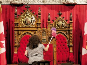 A member of the cleaning staff cleans the Senate thrones in Ottawa, in 2010.