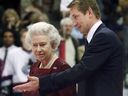 Wayne Gretzky escorts Queen Elizabeth II to centre ice for a ceremonial face-off at GM Place in Vancouver Sunday Oct. 6, 2002.