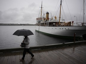 Eine Person schützt sich mit einem Regenschirm, während sie am Ufer von Halifax spazieren geht, während Regen fällt, bevor der Hurrikan Fiona am 23. September 2022 auf Land trifft.