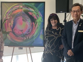 Artist Gina Godfrey has donated her painting Mystical Garden to the Chinese Cultural Centre for the Imperial Ball 2022: Moon Garden Illumia. From left to right is Angela Chan, president of the CCCGT, Godfrey, and Alan Lam, chairman of the CCCGT.