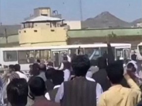 This grab taken from a UGC video posted online on September 30, 2022 shows Iranians hurling stones at a police station in the southeastern city of Zahedan.
