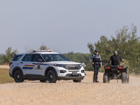 An RCMP officer talks with a resident on James Smith Cree Nation after reports of a possible sighting of fugitive mass-killer Myles Sanderson on the reserve, September 6, 2022.