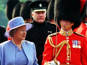 Honorary colonel of the Governor General's Foot Guards, Conrad Black, follows behind Queen Elizabeth ll as she inspects the regiment with the commanding officer, Lt.-Col. Roy Hillier, during  ceremonies at Rideau Hall in Ottawa, on June 30, 1997.