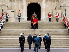 Pall bearers carry the coffin of Queen Elizabeth II with the Imperial State Crown resting on top into St. George's Chapel on September 19, 2022 in Windsor, England.