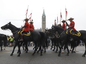 RCMP officers ride past Canada's Parliament Hill as the Government of Canada commemorates the death of Queen Elizabeth II with a ceremony in Ottawa  on September 19, 2022.