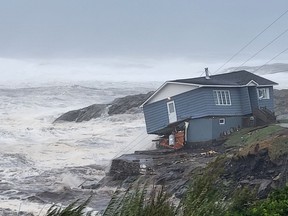 Waves roll in near a damaged house built close to the shore as Hurricane Fiona, later downgraded to a post-tropical cyclone, passes the Atlantic settlement of Port aux Basques, Newfoundland and Labrador, Canada September 24, 2022.
