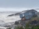Waves roll in near a damaged house built close to the shore as Hurricane Fiona, later downgraded to a post-tropical cyclone, passes the Atlantic settlement of Port aux Basques, Newfoundland and Labrador, Canada September 24, 2022. Courtesy of Wreckhouse Press/Handout via REUTERS