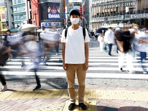 Shoji Morimoto who charges 10,000 yen ($71.30) per booking to accompany clients and simply exist as a companion, poses at Shibuya crossing in Tokyo, Japan.