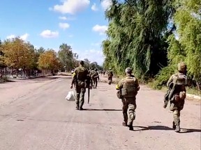 Ukrainian soldiers walk through Vysokopillya, Kherson region, after reportedly taking the area back from Russian occupiers, recently.
