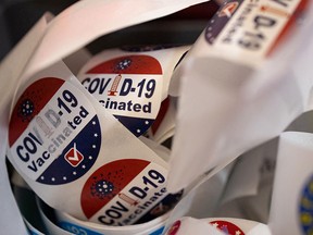 Patients receive stickers after receiving a bivalent booster vaccine targeting the BA.4 and BA.5 Omicron sub-variants at a pharmacy in Schwenksville, Pa., on Sept. 8, 2022. The bivalent boosters being administered in Canada target the less prevalent BA.1 variant.