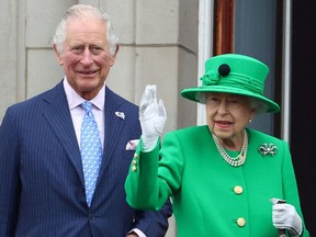 The late Queen Elizabeth II stands beside Britain's Prince Charles, Prince of Wales and waves to the public from the Buckingham Palace balcony during platinum jubilee celebrations.