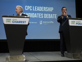 Conservative leadership candidates Jean Charest and Pierre Poilievre wait at their positions as other leadership candidates take to the stage at the start of a debate at the Canada Strong and Free Network conference, Thursday, May 5, 2022 in Ottawa. The Conservative party is giving itself a head start on counting the tens of thousands of ballots it received to determine who will be its next leader.