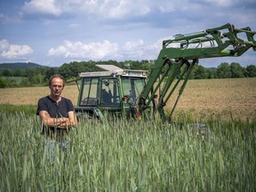 FILE - Ulf Allhoff-Cramer, farmer, stands in a rye field in front of his tractor in Detmold, Germany, on May 18, 2022. Environmentalists claimed a small legal victory Friday, Sept. 9, 2022, after a court in Germany said it would continue hearing a case brought by a local farmer seeking to force automaker Volkswagen to the sale of combustion engine vehicles. The plaintiff, Ulf Allhoff-Cramer, says drier soil and heavier rains due to climate change are harming his fields, cattle and commercial forests.