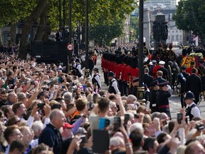 The coffin of Queen Elizabeth II, draped in the Royal Standard with the Imperial State Crown placed on top, is carried on a horse-drawn gun carriage of the King's Troop Royal Horse Artillery, during a procession for the Lying-in State of Queen Elizabeth II from Buckingham Palace to Westminster Hall in London, Wednesday, Sept. 14, 2022. The Queen will lie in state in Westminster Hall for four full days before her funeral on Monday Sept. 19.