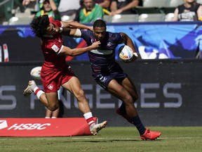 United States' Davis Still, right fends ion the challenge of Canada's Brock Webster during rugby sevens action in Carson, Calif., Saturday, Aug. 27, 2022.&ampnbsp;After falling to Uruguay earlier in the day, the Canadian men survived a 19-point Welsh comeback in the second half to win 33-19 in consolation play at the Rugby World Cup Sevens on Saturday.