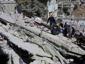 Rescue teams from the Jordanian Civil Defense carry out a search operation for residents of a four-storey apartment building that collapsed on Tuesday, in the Jordanian capital, Amman, Thursday, Sept. 15, 2022. Jordanian officials say the death toll from the collapse this week of the four-story building in the Jordanian capital of Amman has climbed. Rescuers were still searching for a missing woman on Friday.