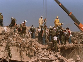 FILE - Rescue workers sift through the rubble of the U.S. Marine base in Beirut in Oct. 23, 1983 following a massive bomb blast that destroyed the base and killed 241 American servicemen. Iran told the United Nation's highest court on Monday, Sept. 19, 2022, that Washington's confiscation of some $2 billion in assets from Iranian state bank accounts to compensate bombing victims was an attempt to destabilize the Iranian government and a violation of international law. The U.S. Supreme Court in 2016 ruled money held in Iran's central bank could be used to compensate victims of the 1983 bombing linked to Iran. (AP Photo, File)