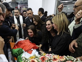 FILE - Colleagues and friends react as the Palestinian flag-draped body of veteran Al-Jazeera journalist Shireen Abu Akleh is brought to the news channel's office in the West Bank city of Ramallah, May 11, 2022. Israel's decision to absolve itself of responsibility for the shooting death of Abu Akleh drew criticism from international media on Thursday, Sept. 8, 2022, marking a further deterioration of relations between the military and reporters covering the conflict. The military said that neither the soldier nor commanders would face any punishment.