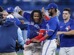 Toronto Blue Jays first baseman Vladimir Guerrero Jr. (27) celebrates with teammates after hitting the game winning RBI single against the New York Yankees during tenth inning American League MLB baseball action in Toronto on Monday, September 26, 2022.