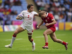 England's Abbie Brown, left, is tackled by Canada's Piper Logan during the Women's Pool A Rugby Sevens match at Coventry Stadium on day one of the 2022 Commonwealth Games in Coventry, England, Friday July 29, 2022.
