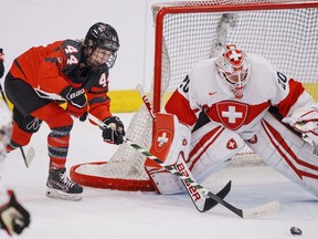 Sarah Potomak of Canada in action with goalkeeper Andrea Braendli of Switzerland during The IIHF World Championship Woman's ice hockey match between Canada and Switzerland in Herning, Denmark, Saturday, Aug. 27, 2022. A unified North American women's pro hockey league could bolster the international game in the same way the NHL does on the men's side, says the International Ice Hockey Federation's women's committee chair.