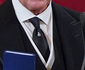 Eine Nahaufnahme einer silbernen Krawattennadel, die König Karl III. am Sonntag, den 11. September 2022 in der St. James Cathedral in London trug. Die Nadel zeigt die königliche Chiffre des Großvaters des Königs, George VI.