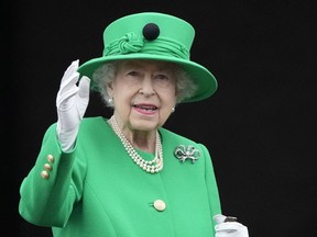 Queen Elizabeth II waves to the crowd during the Platinum Jubilee Pageant at the Buckingham Palace in London, Sunday, June 5, 2022.