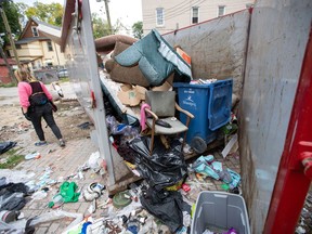 Angela Klassen Janeczko walks by a newly installed and overflowing garbage container behind an apartment building during a Bear Clan patrol in Winnipeg's West Broadway neighbourhood on Sunday, Sept. 18, 2022.