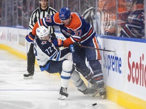 Winnipeg Jets' Leon Gawanke (72) is checked by Edmonton Oilers' Warren Foegele (37) during second period pre-season action in Edmonton, Sunday, Sept. 25, 2022.