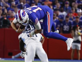 Buffalo Bills quarterback Josh Allen (17) leaps over Tennessee Titans' Roger McCreary (21) during the first half of an NFL football game Monday, Sept. 19, 2022, in Orchard Park, N.Y.