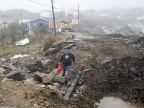 Lindsey Fudge carries groceries through the devastation left by hurricane Fiona in Burnt Island, Newfoundland on Wednesday September 28, 2022. The federal government announced this afternoon that it is extending tax relief to people, businesses&ampnbsp; and charities affected by Hurricane Fiona in Atlantic Canada.