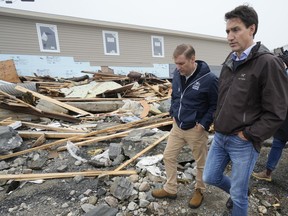 Prime Minister Justin Trudeau, right, and Newfoundland and Labrador Premier Andrew Furey tour the damage cause by post-tropical storm Fiona in Port aux Basques, N.L. on Wednesday, Sept. 28, 2022.