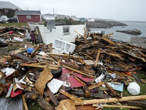 A resident and search and rescue worker examine the destroyed remains of a home in Port aux Basques, N.L., Monday, Sept.26, 2022. Post-tropical storm Fiona carved a path of devastation across parts of Atlantic Canada, leaving behind smashed homes, roads strewn with debris and hundreds of thousands of people without power.