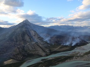 The Chetamon wildfire is seen burning beside Mount Greenock, left, in Jasper National Park in a Sept. 7, 2022, handout photo. Jasper National Park has already advised people not to visit due to power outages caused by the Chetamon Mountain blaze that have disrupted services within the park, including the Jasper townsite.