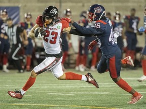 Ottawa Redblacks' Jaelon Acklin (23) holds off a tackle from Montreal Alouettes' Kenneth Durden during first half CFL football action in Montreal, Friday, Sept. 2, 2022.