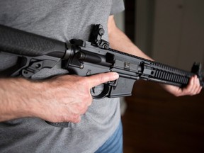 A restricted gun licence holder holds a AR-15 at his home in Langley, B.C. on May 1, 2020.