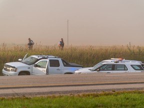 Police and investigators are seen at the side of the road outside Rosthern, Sask., on Wednesday, Sept. 7, 2022. The chief of a Saskatchewan First Nation is to speak the day after the suspect in a deadly stabbing rampage died after being taken into police custody. Myles Sanderson went into medical distress shortly after being arrested Wednesday, bringing an end to a four-day manhunt.