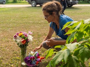 Ruby Works places flowers at the home of a victim who has been identified by residents as Wes Petterson in Weldon, Sask., on Monday, Sept. 5, 2022. Works said that the 77-years-old victim was like an uncle to her. Saskatchewan RCMP say arrest warrants have been issued for two suspects in the deadly stabbing rampage.