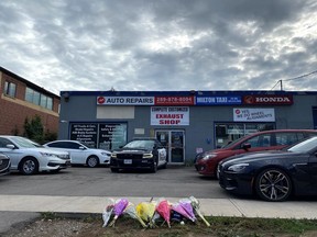 Flowers are laid outside a business in Milton, Ont., Tuesday, Sept. 13, 2022. Shakeel Ashraf, who owned MK Auto Repairs, was shot and killed during a string of shootings across the Greater Toronto and Hamilton Area.