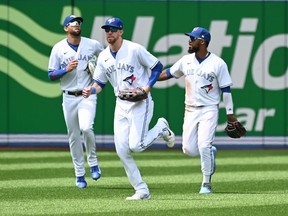 Toronto Blue Jays, from left, Lourdes Gurriel Jr., Bradley Zimmer and Teoscar Hernandez run in from the outfield after defeating the Detroit Tigers in American League baseball action in Toronto, Sunday, July 31, 2022. Outfielder Zimmer and relief pitcher Casey Lawrence have been added to the Toronto Blue Jays roster.THE CANADIAN PRESS/Jon Blacker