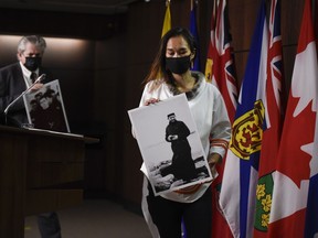 NDP MP Mumilaaq Qaqqaq holds a photo of Johannes Rivoire, who is wanted in Canada for abusing children in Nunavut but now resides in France, arrives for a news conference calling on Minister of Justice David Lametti to investigate crimes against Indigenous people in Canada at residential schools, on Parliament Hill in Ottawa, on Thursday, July 8, 2021. An Inuk man who alleges he was sexually abused by a former Oblate priest in Nunavut when he was 13 years old says meeting the man face-to-face after nearly three decades was a relief.