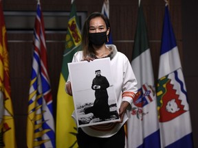 Former NDP MP Mumilaaq Qaqqaq holds a photo of Fr. Johannes Rivoire, who is wanted in Canada on abuse allegations in Nunavut, but now resides in France, at a news conference on Parliament Hill in Ottawa, Thursday, July 8, 2021. The leadership of a Catholic order in France has begun dismissal proceedings against a priest accused of sexual abusing Inuit children in Nunavut.
