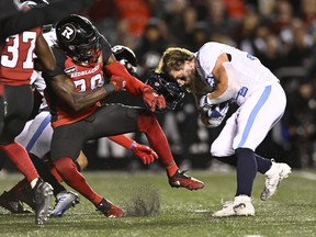 Toronto Argonauts running back AJ Ouellette (34) loses his helmet as Ottawa Redblacks linebacker Frankie Griffin (28) attempts to tackle him, during first half CFL football action in Ottawa on Saturday, Sept. 24, 2022.