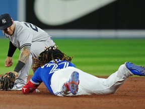 Toronto Blue Jays designated hitter Vladimir Guerrero Jr. (27) is tagged out at second base by New York Yankees second baseman Gleyber Torres (25) after hitting an RBI single during sixth inning American League MLB baseball action in Toronto on Tuesday, September 27, 2022.