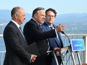 Coalition Avenir Québec Leader François Legault unveils his program on health, Friday, Sept. 2, 2022, in Lévis. Legault is flanked by candidates Christian Dubé, left, ad Bernard Drainville. Quebecers are going to the polls for a general election on Oct. 3.