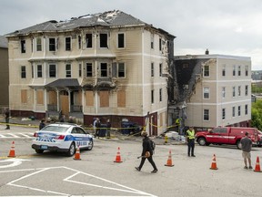 FILE - Officials investigate the scene of a fatal fire, Tuesday, May 17, 2022 in Worcester, Mass. A former tenant is heading to court Friday, Sept. 30 to face arson and murder charges in connection with a fire at a Massachusetts apartment building last May that claimed the lives of four people, including a man who had sued right-wing radio host Alex Jones ' Infowars website.